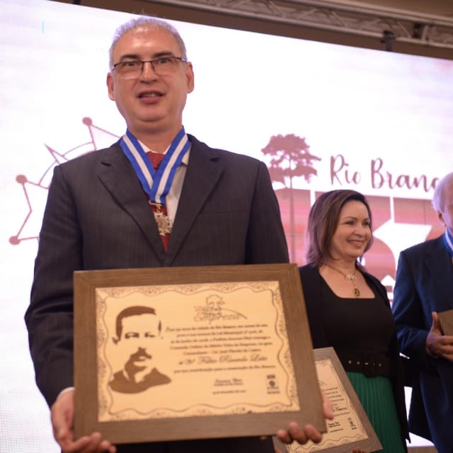 Rico Leite recebendo homenagem com medalha e placa comemorativa